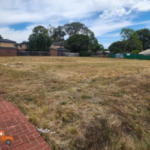 Vacant block in suburb Heathmont after professional ride-on mowing service showing neatly cut grass